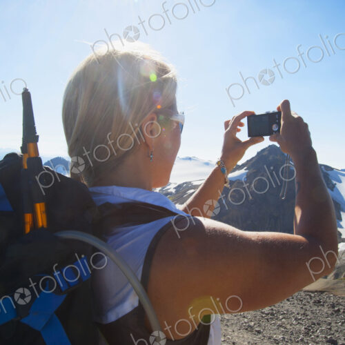 Woman taking photograph of remote mountains