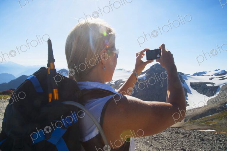 Woman taking photograph of remote mountains