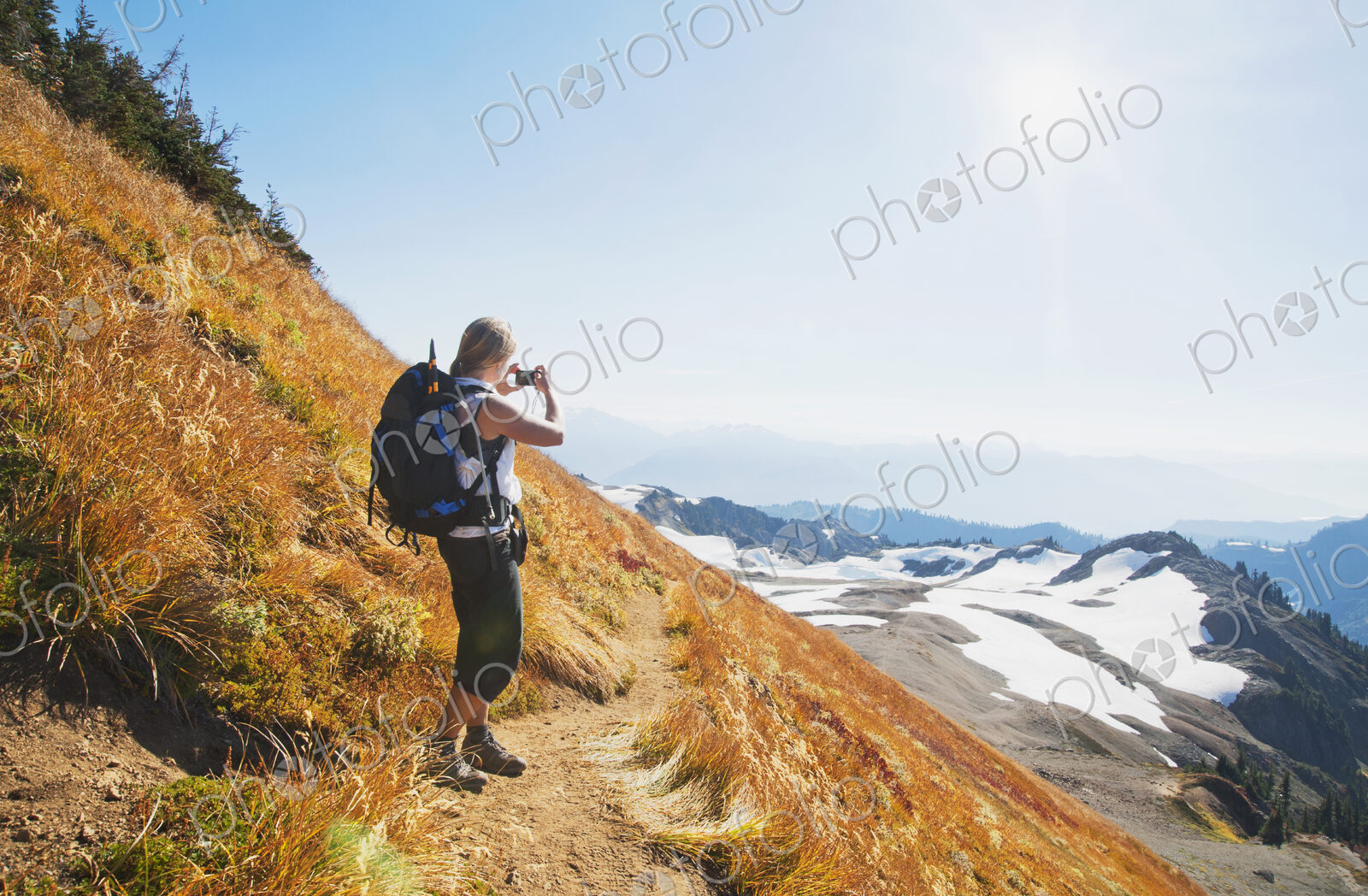 Woman taking photograph of remote mountains on hillside