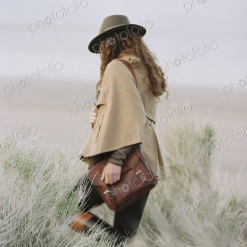Woman walking across grassland.