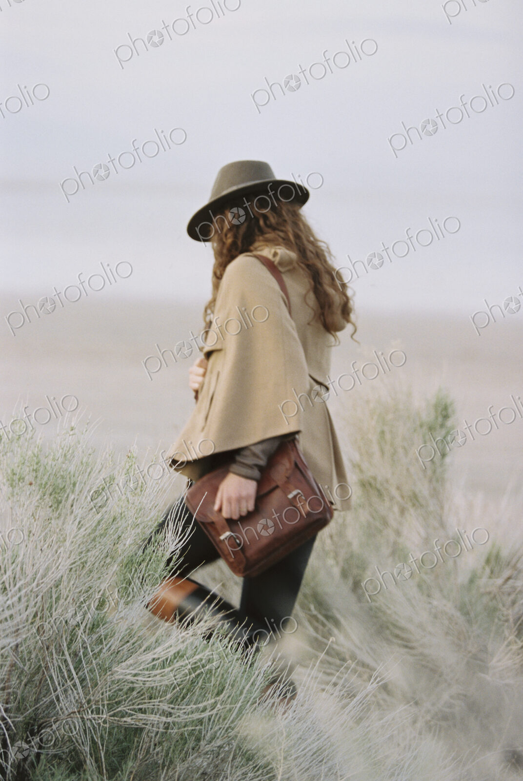 Woman walking across grassland.