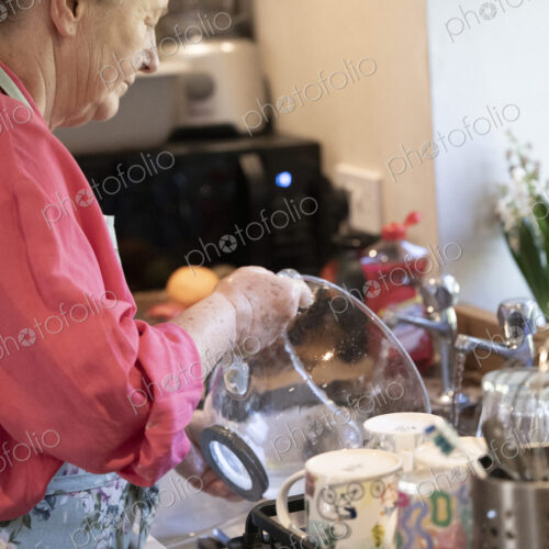 Woman washing the dishes in kitchen.