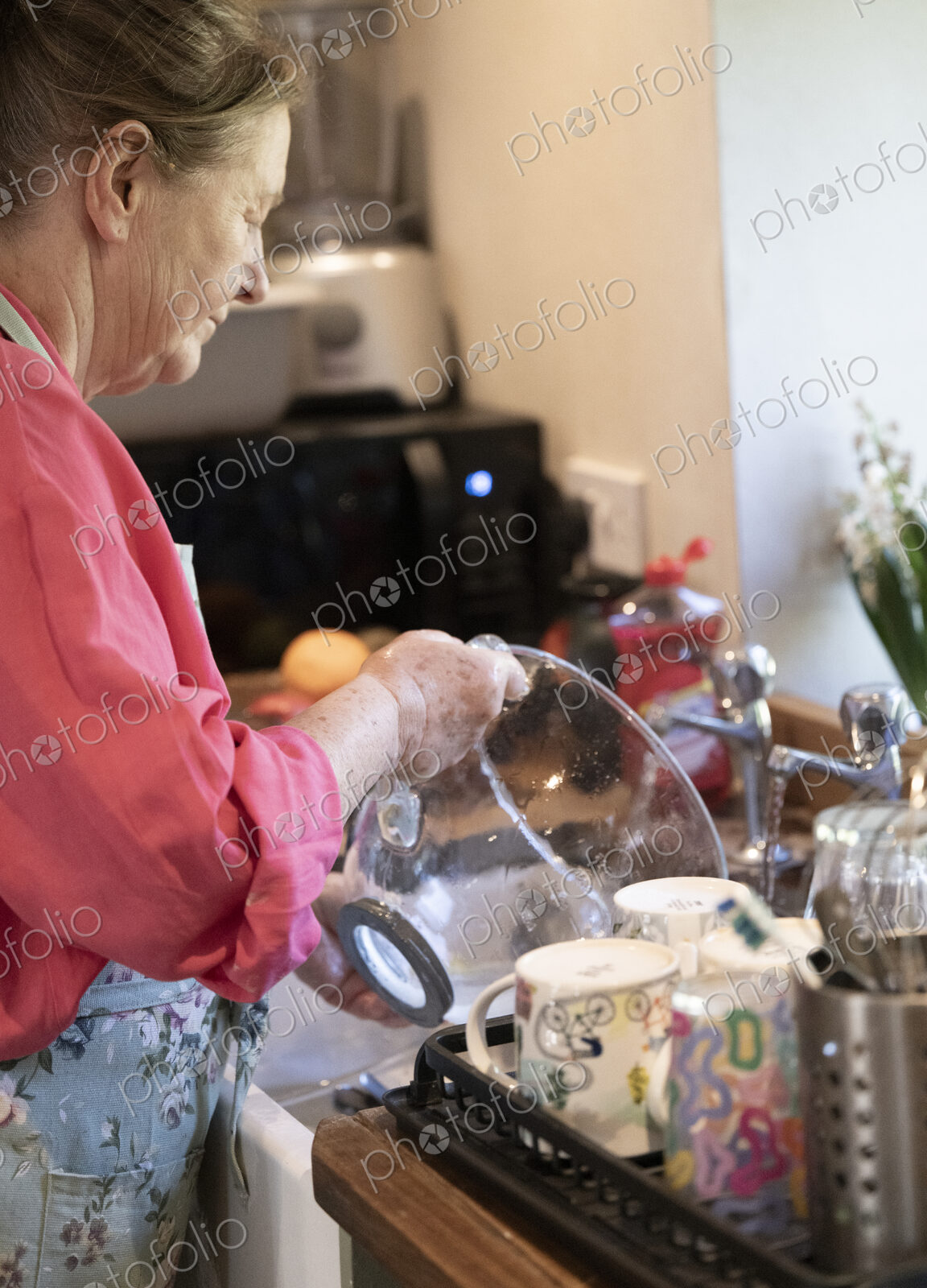 Woman washing the dishes in kitchen.