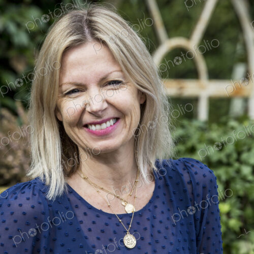 Woman with blond hair and wearing blue top standing outdoors, smiling at camera. Woman with blond hair and wearing blue top standing outdoors, smiling at camera.