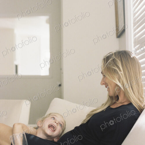 Woman with long blond hair wearing a black dress, sitting on a sofa, holding a glass,… Woman with long blond hair wearing a black dress, sitting on a sofa, holding a glass,…