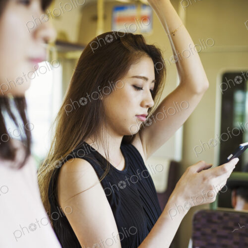 Woman with long brown hair traveling on public transport, using mobile phone. Woman with long brown hair traveling on public transport, using mobile phone.