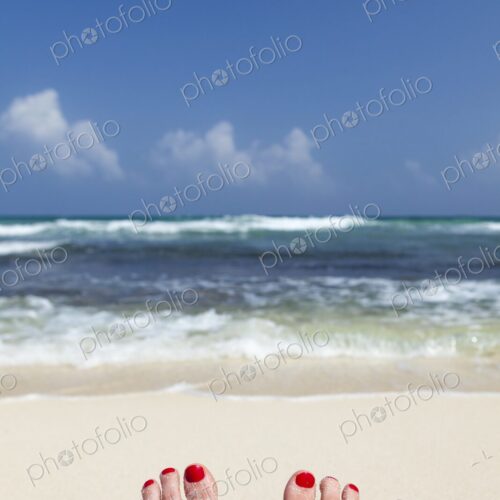 Woman's feet with red nail polish, resting on beach in Tulum, Mexico, facing turquoise… Woman's feet with red nail polish, resting on beach in Tulum, Mexico, facing turquoise…