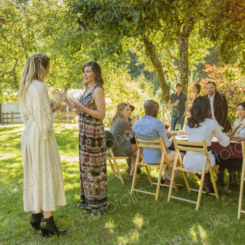 Women standing and talking at party outdoors Women standing and talking at party outdoors