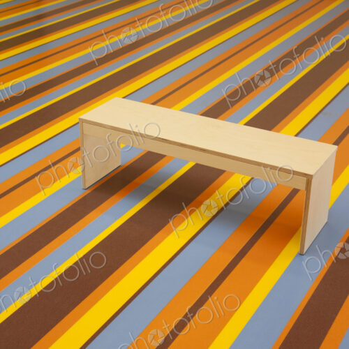 Wooden Bench on a vibrant Striped Floor
