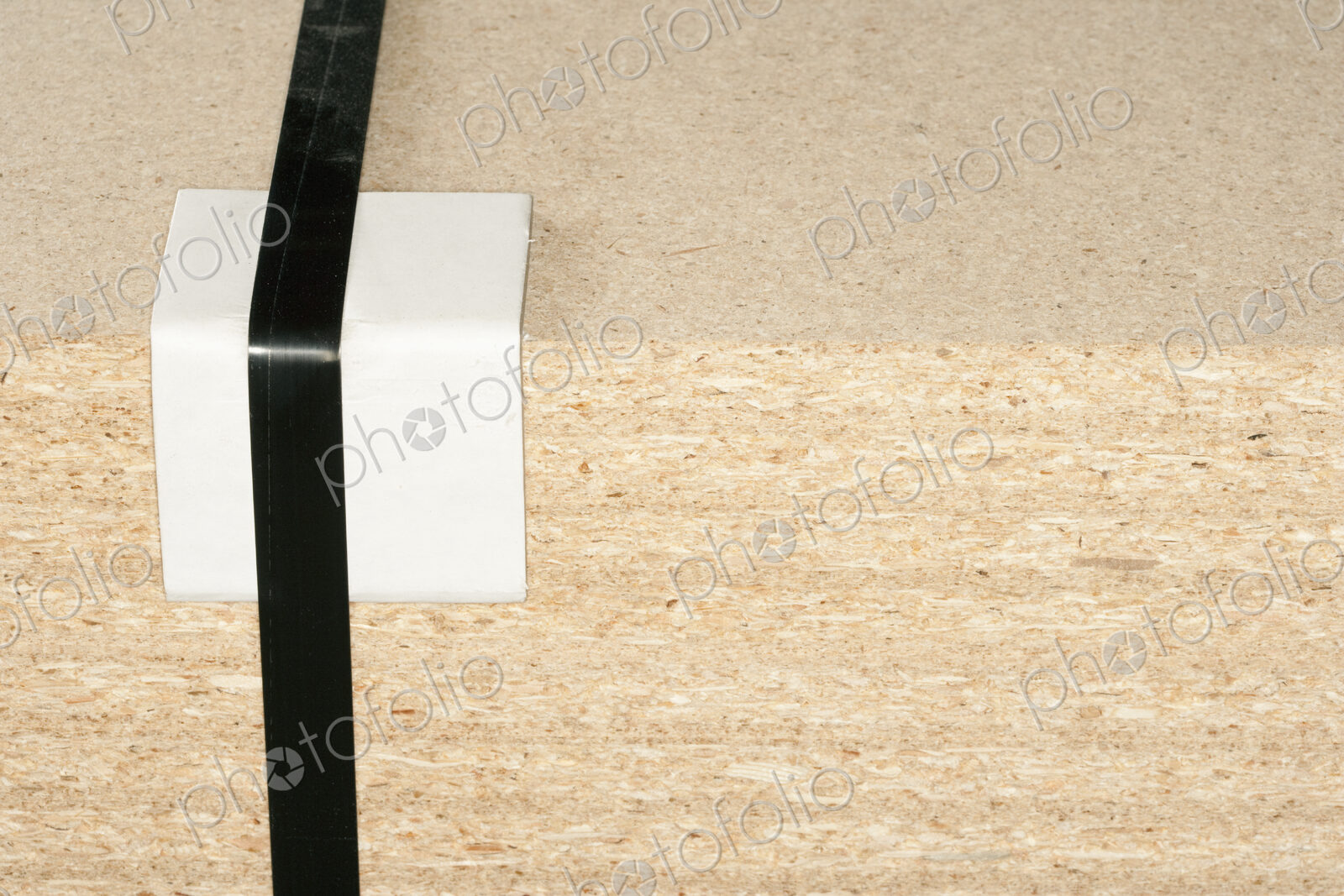 Wooden block with tape and bumper block to protect corner.