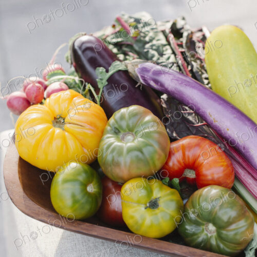 Wooden bowl with fresh vegetables standing on a table. Wooden bowl with fresh vegetables standing on a table.