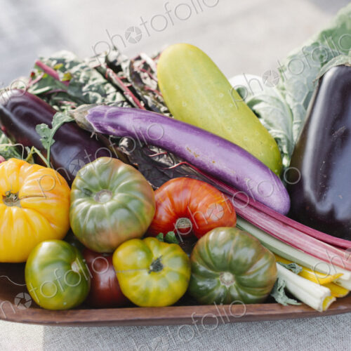 Wooden bowl with fresh vegetables standing on a table. Wooden bowl with fresh vegetables standing on a table.