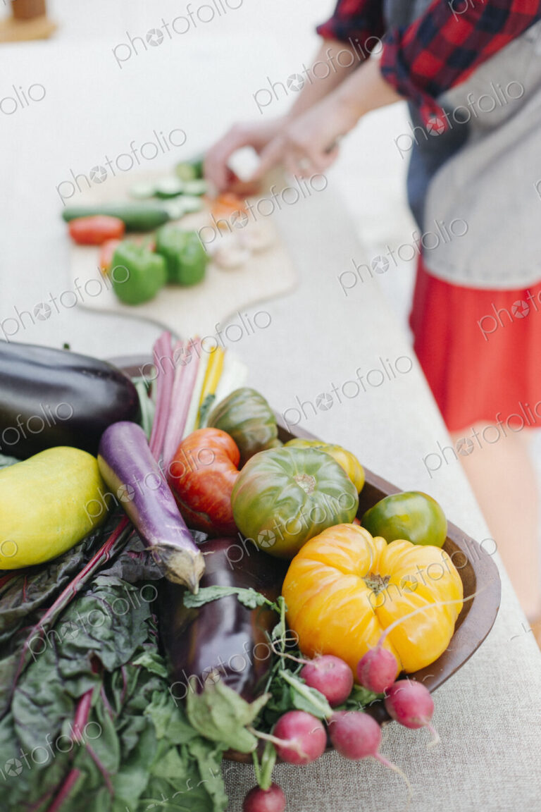 Wooden bowl with fresh vegetables standing on a table.
