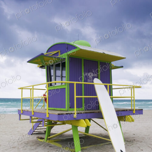 Wooden colourful lifeguard hut on a sandy beach.