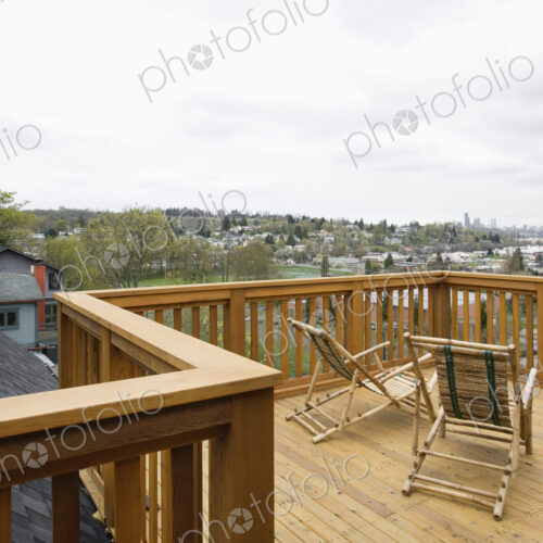 Wooden house balcony looking out over urban area.