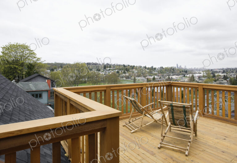 Wooden house balcony looking out over urban area.