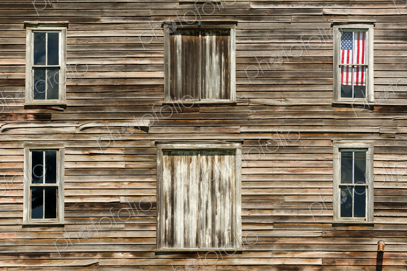 Wooden house exterior with American flag in window