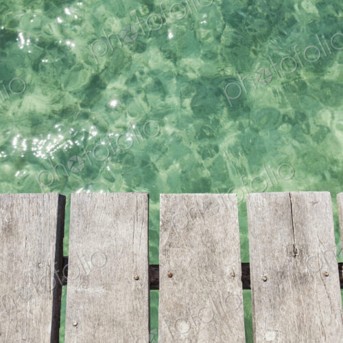 Wooden pier over shallow clear turquoise blue water Wooden pier over shallow clear turquoise blue water