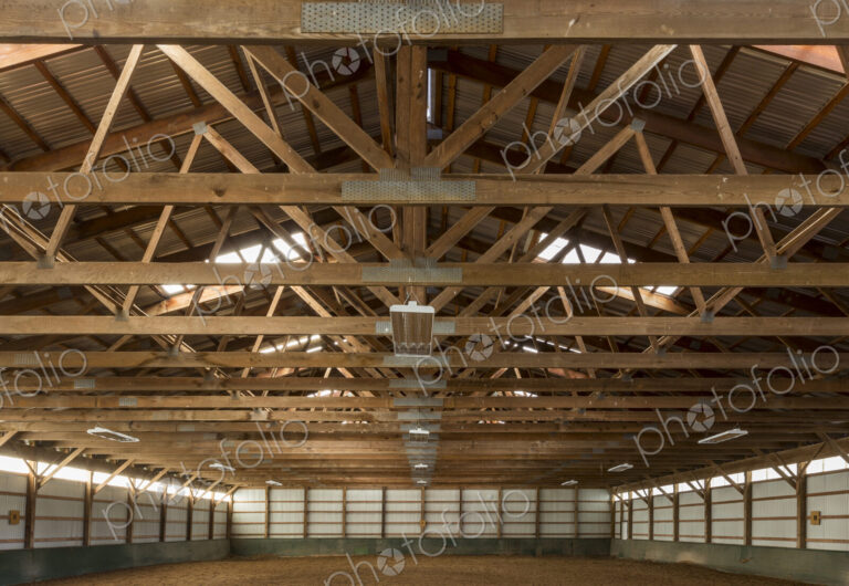 Wooden rafters in indoor horse riding ring