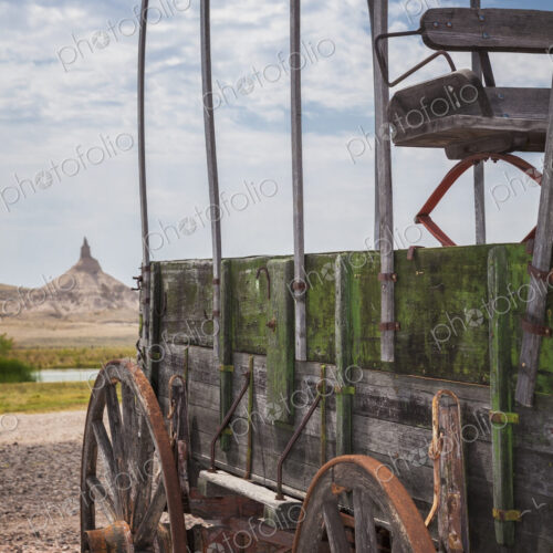 Wooden wagon and Chimney Rock, Nebraska, United States Wooden wagon and Chimney Rock, Nebraska, United States
