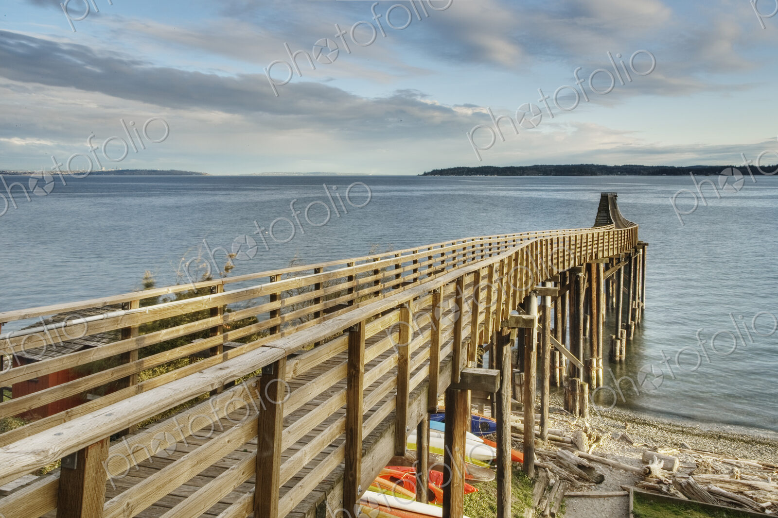 Wooden walkway on beach down to water.