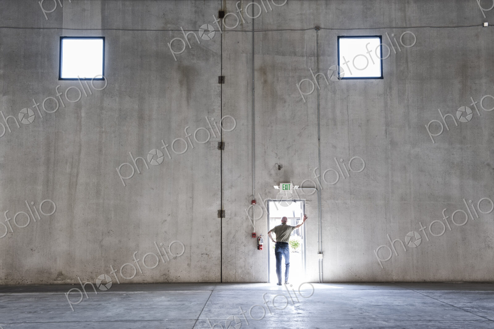 Worker standing silhouetted in doorway of new warehouse.