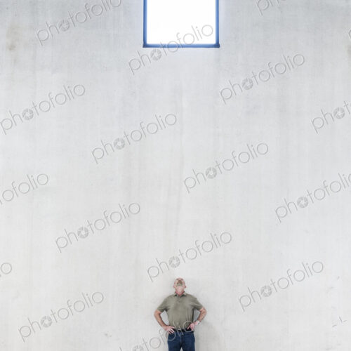 Worker standing under a window in a new warehouse. Worker standing under a window in a new warehouse.