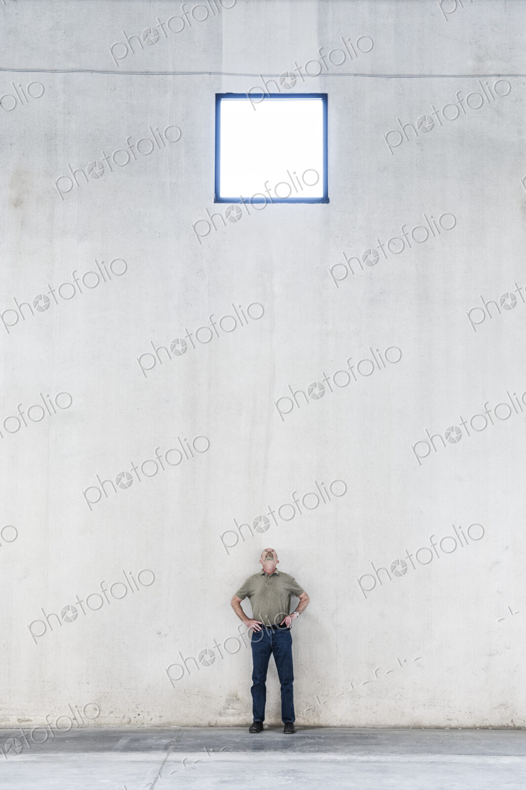 Worker standing under a window in a new warehouse.