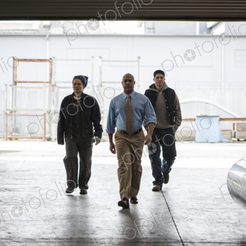 Workers and management person walking through a door into a sheet metal factory. Workers and management person walking through a door into a sheet metal factory.