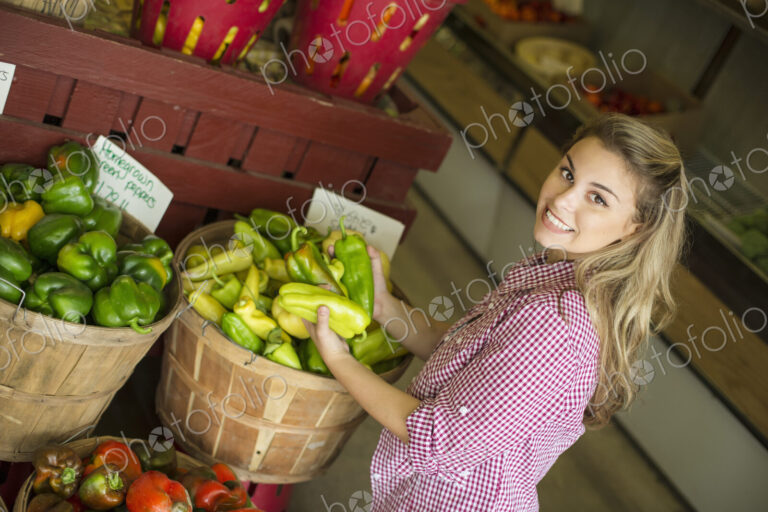 Working on an organic farm. A young blonde haired woman sorting different types of…