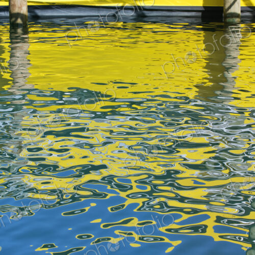 Yellow boat reflected in water
