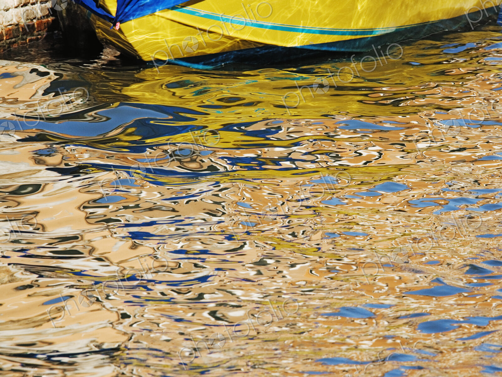 Yellow moored boat with reflections in water.