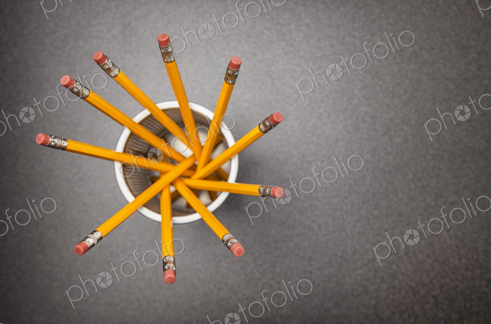 Yellow no.2 pencils in cup on desk in business office or school, view from above