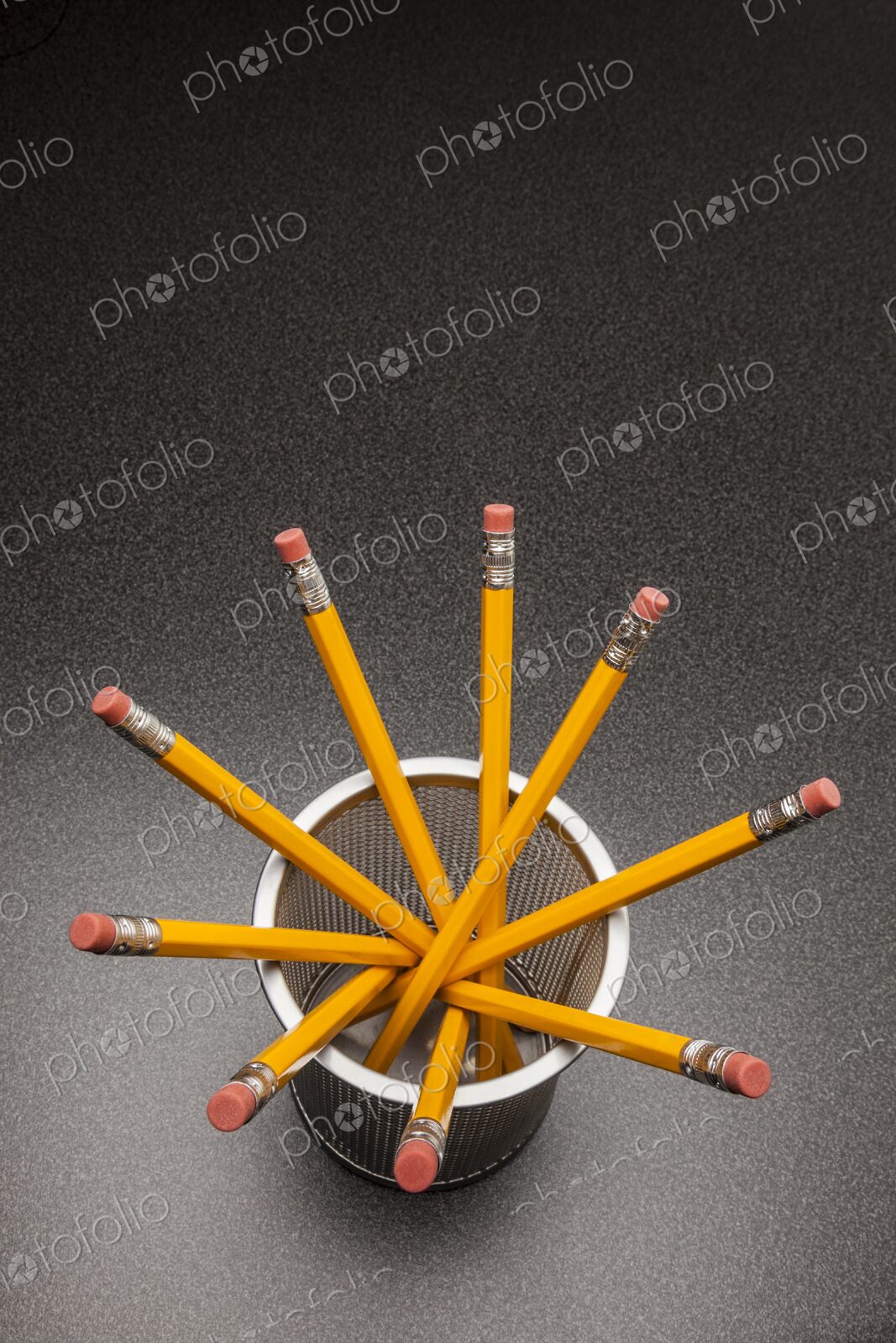 Yellow no.2 pencils in cup on desk in business office or school, view from above