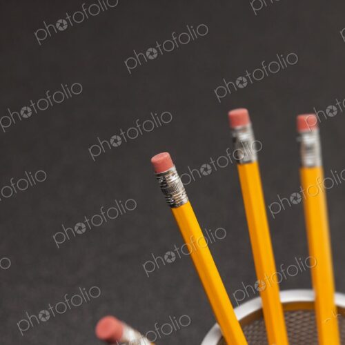 Yellow number 2 pencils in cup on desk in business office or school, selective focus