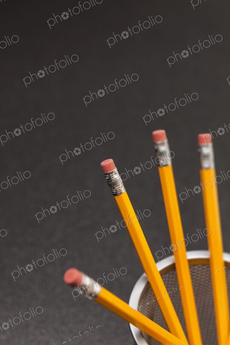 Yellow number 2 pencils in cup on desk in business office or school, selective focus