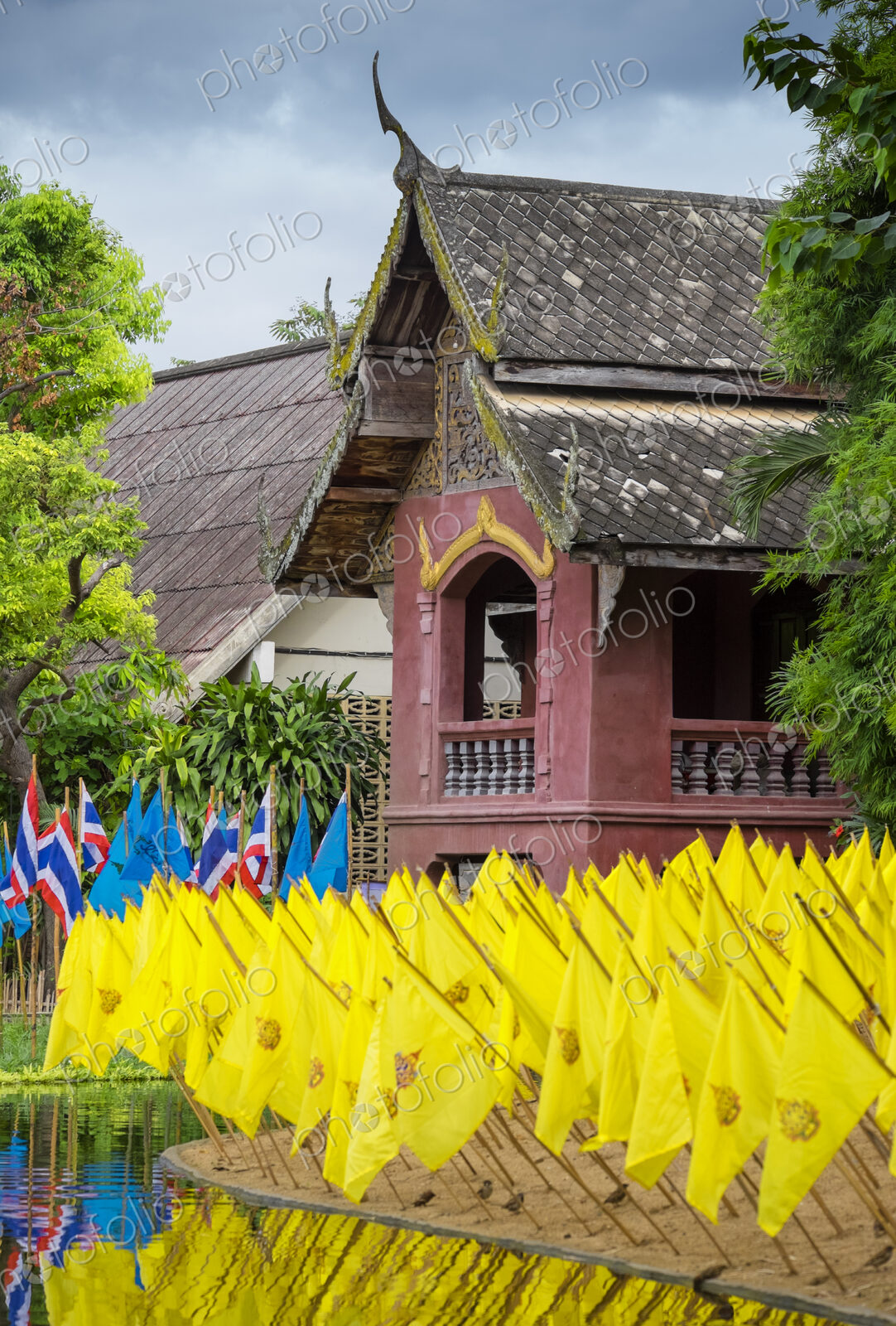 Yellow prayer flags in front of a wat temple, bright colours.