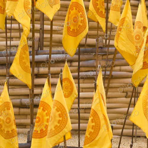 Yellow prayer flags stuck in sand at a wat temple. Yellow prayer flags stuck in sand at a wat temple.