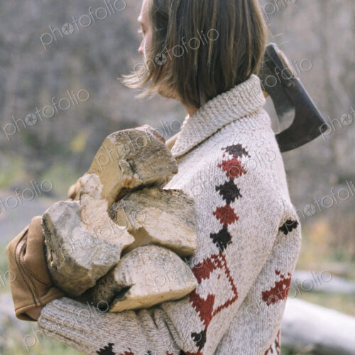 Young blond man carrying firewood. Young blond man carrying firewood.