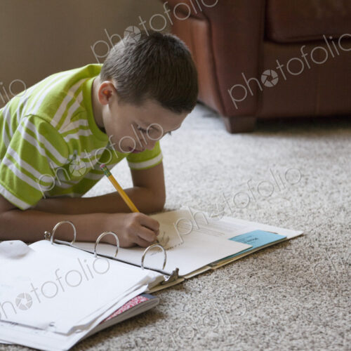 Young boy at home doing homework.
