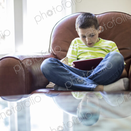 Young boy working on a notebook computer at home Young boy working on a notebook computer at home
