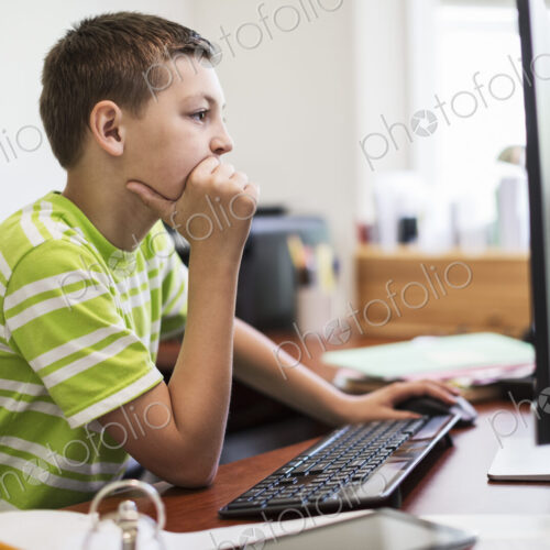 Young caucasian boy at work on a desktop computer system. Young caucasian boy at work on a desktop computer system.