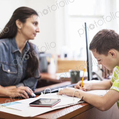 Young caucasian boy working in his mom's home office. Young caucasian boy working in his mom's home office.