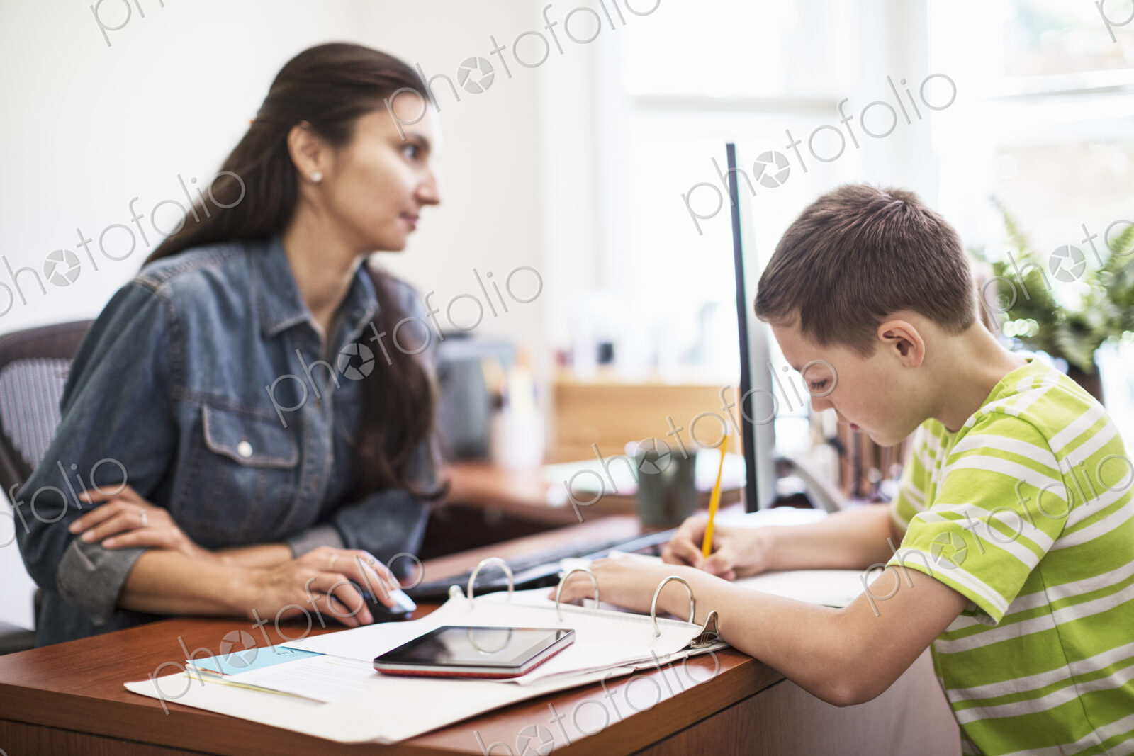 Young caucasian boy working in his mom’s home office.