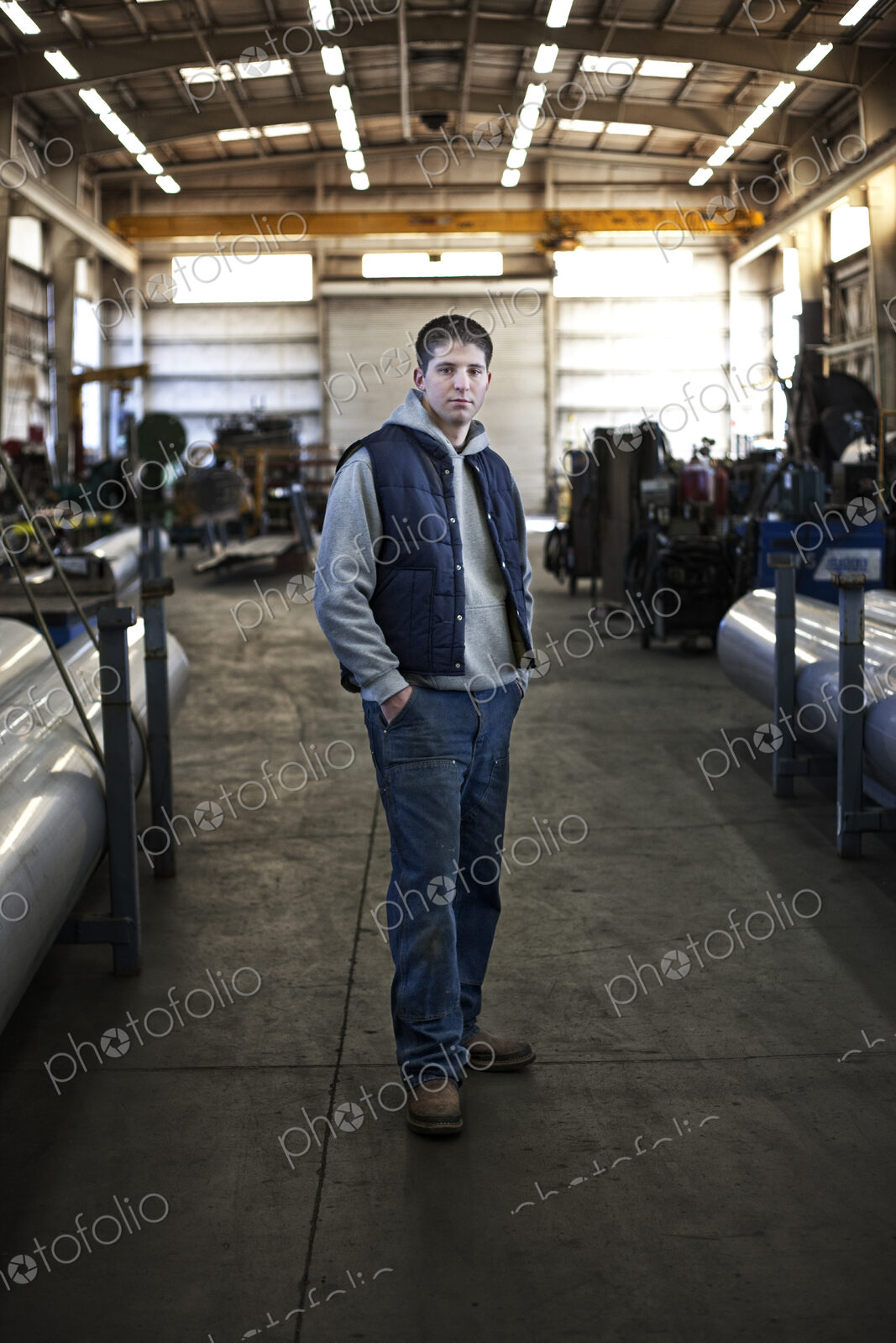 Young caucasian man factory worker standing in a sheet metal factory.
