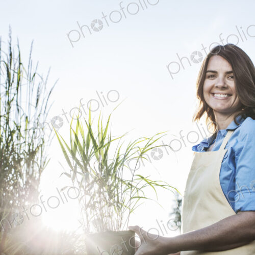Young caucasian woman employee of a garden center and plant nursery. Young caucasian woman employee of a garden center and plant nursery.