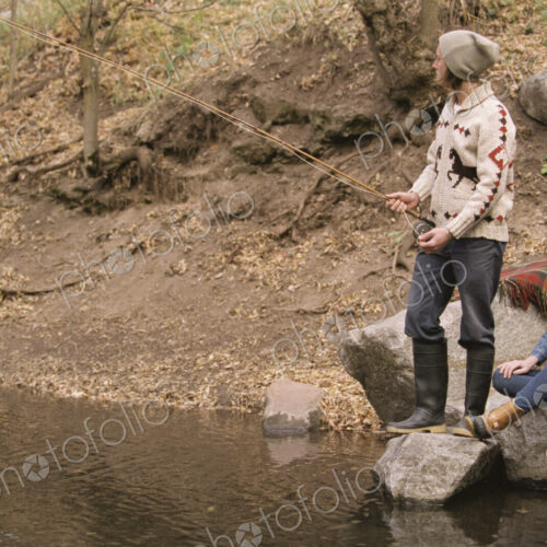 Young couple in a forest, fishing in a river. Young couple in a forest, fishing in a river.