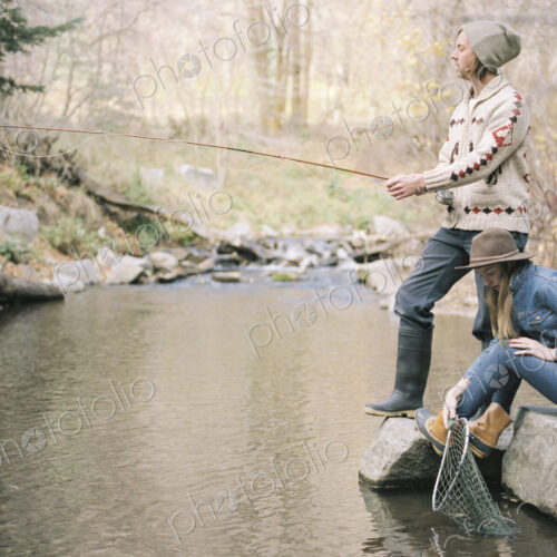 Young couple in a forest, fishing in a river. Young couple in a forest, fishing in a river.