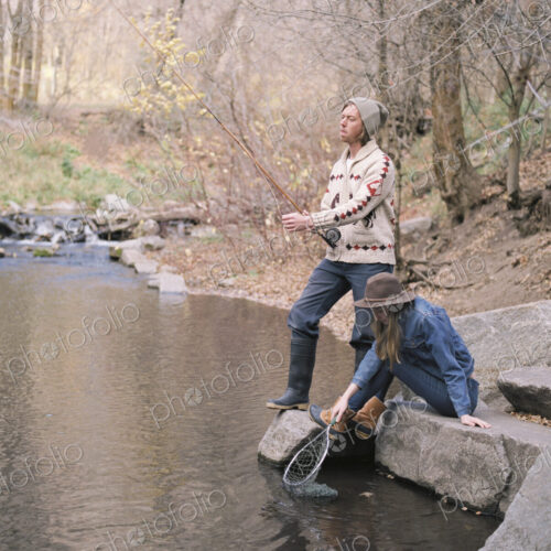 Young couple in a forest, fishing in a river. Young couple in a forest, fishing in a river.
