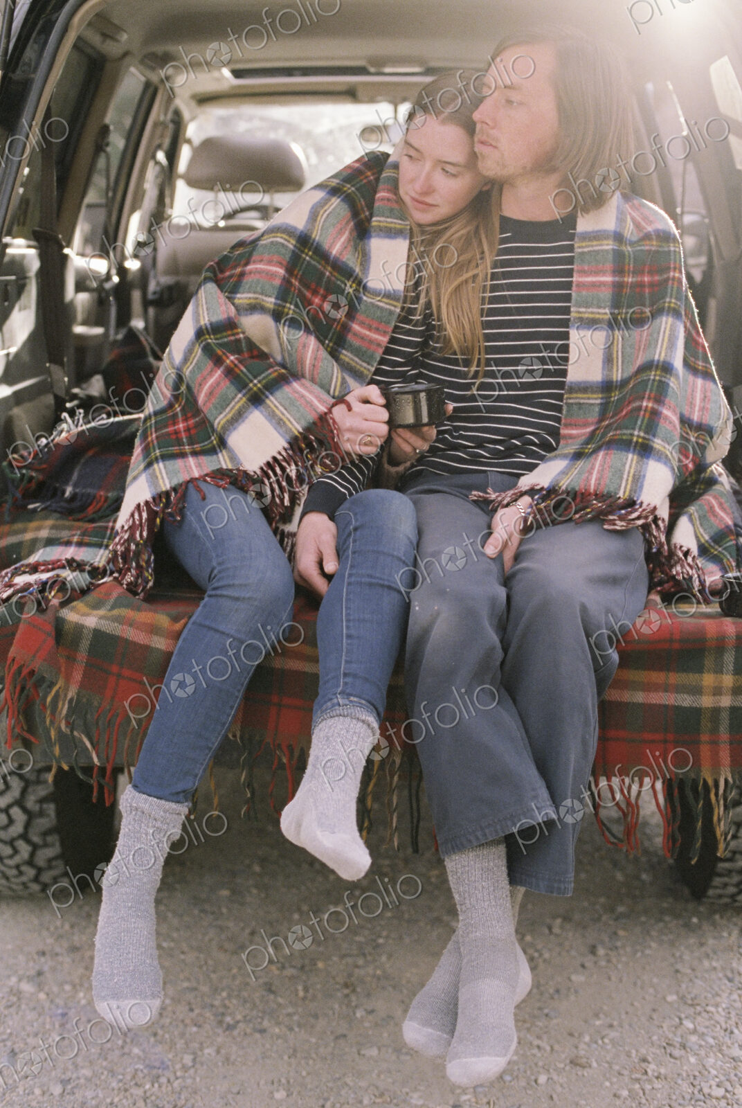 Young couple sitting in the back of their car.